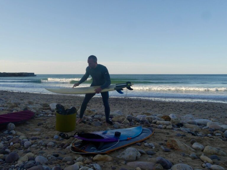 Surf guide algarve guest waxing surfboard at Cabanas Velhas