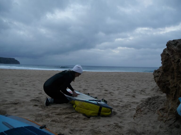 waxing the surfboard with surf guide algarve on the beach