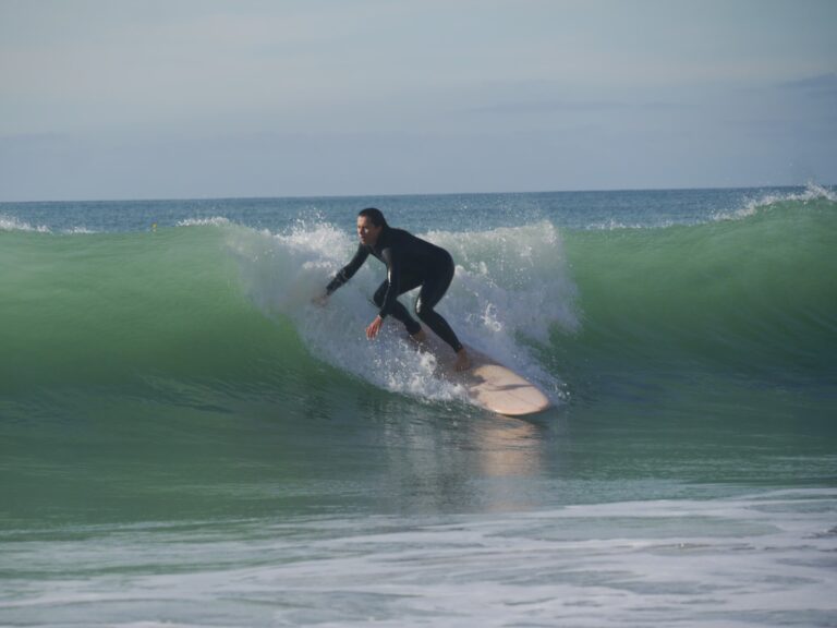 surfer girl take off at porto de mos with surf guide algarve